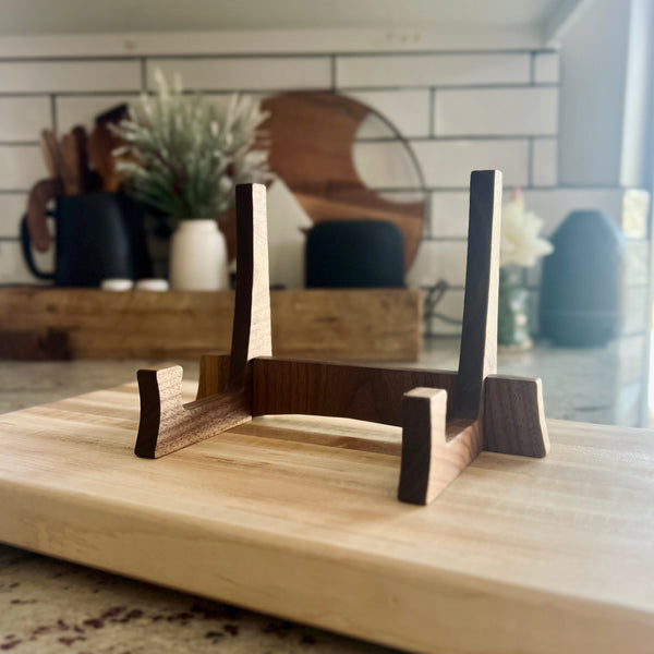 Walnut cutting board stand sitting on a maple cutting board